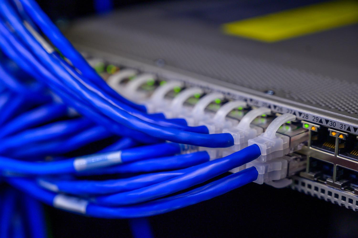 Cables de red Ethernet conectados a un switch, simbolizando el flujo de datos y el túnel cifrado de una VPN