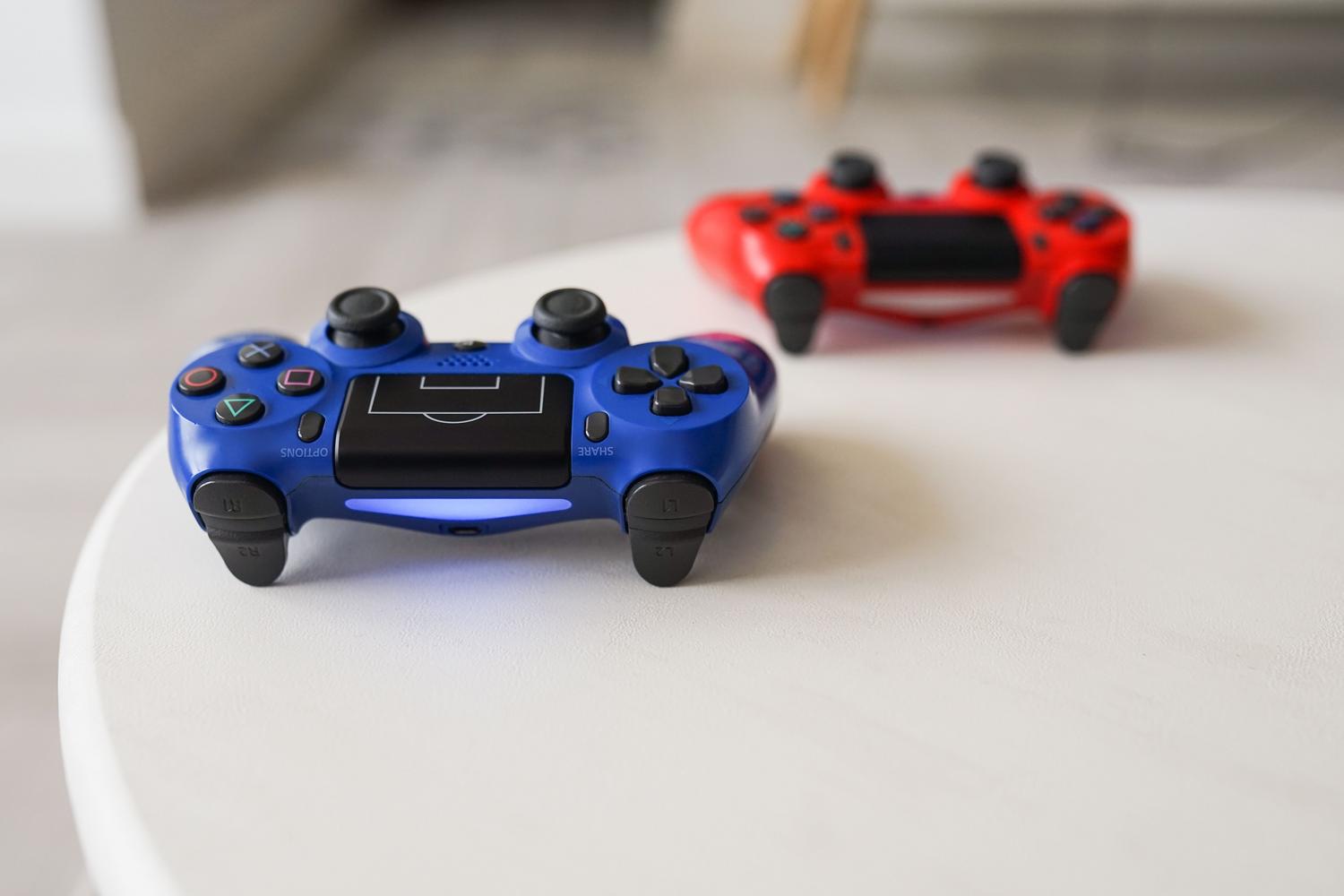 Controles de PlayStation DualShock sobre una mesa blanca, ilustrando la consola a emular.