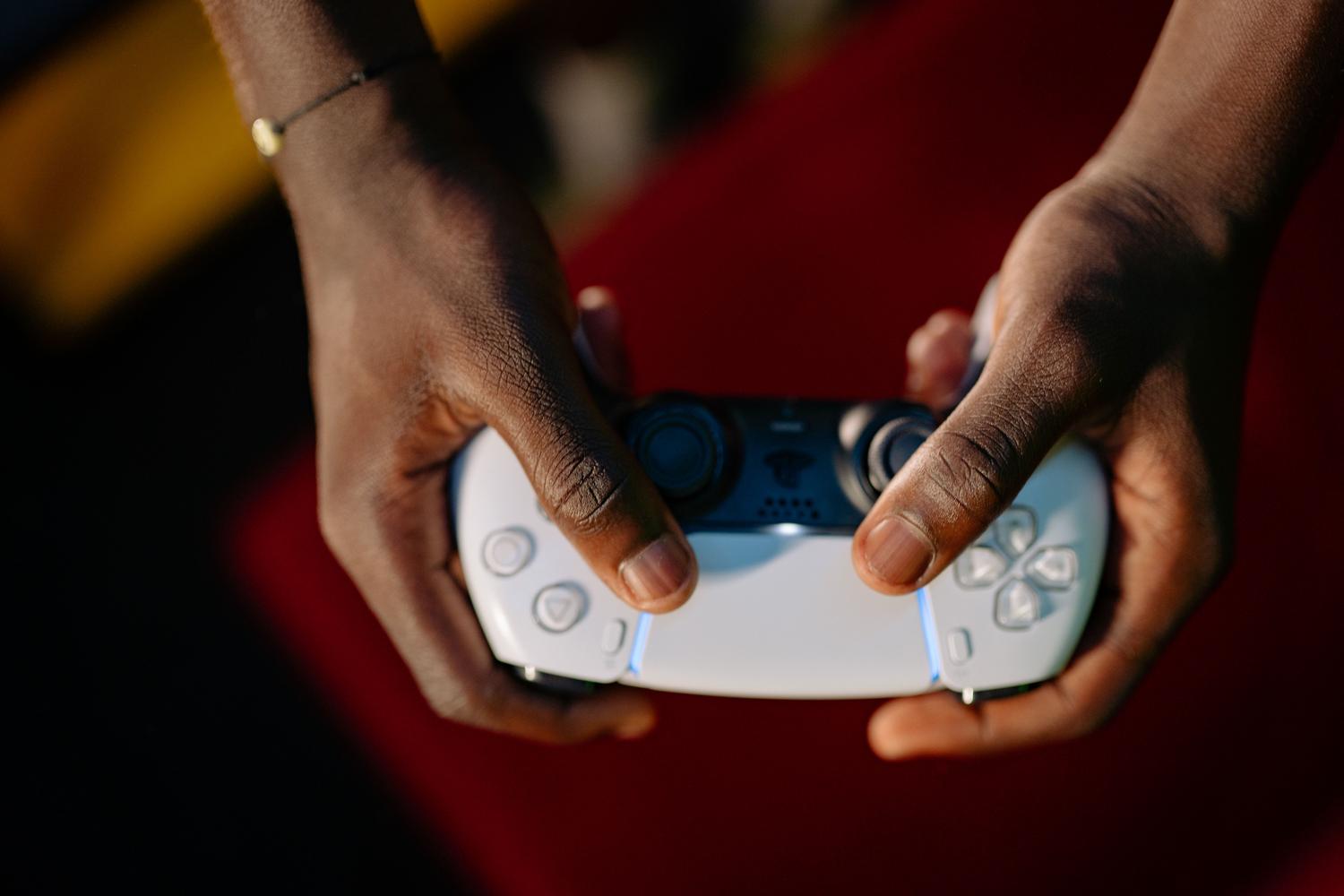 Primer plano de unas manos sosteniendo un mando de PlayStation, representando la experiencia inmersiva de jugar títulos emulados.