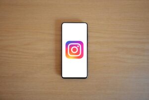 Un smartphone con el logotipo de Instagram en pantalla sobre una superficie de madera, ideal para introducir el tema de la personalización de la plataforma.