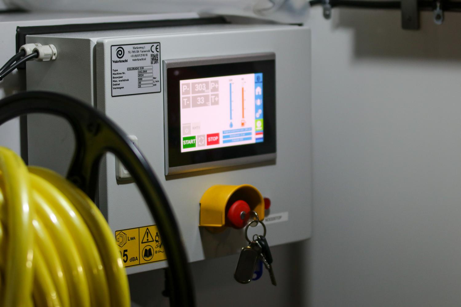 Panel de control industrial moderno con pantalla HMI y botones de emergencia, representando la ciberseguridad en entornos de Tecnología Operativa (OT).