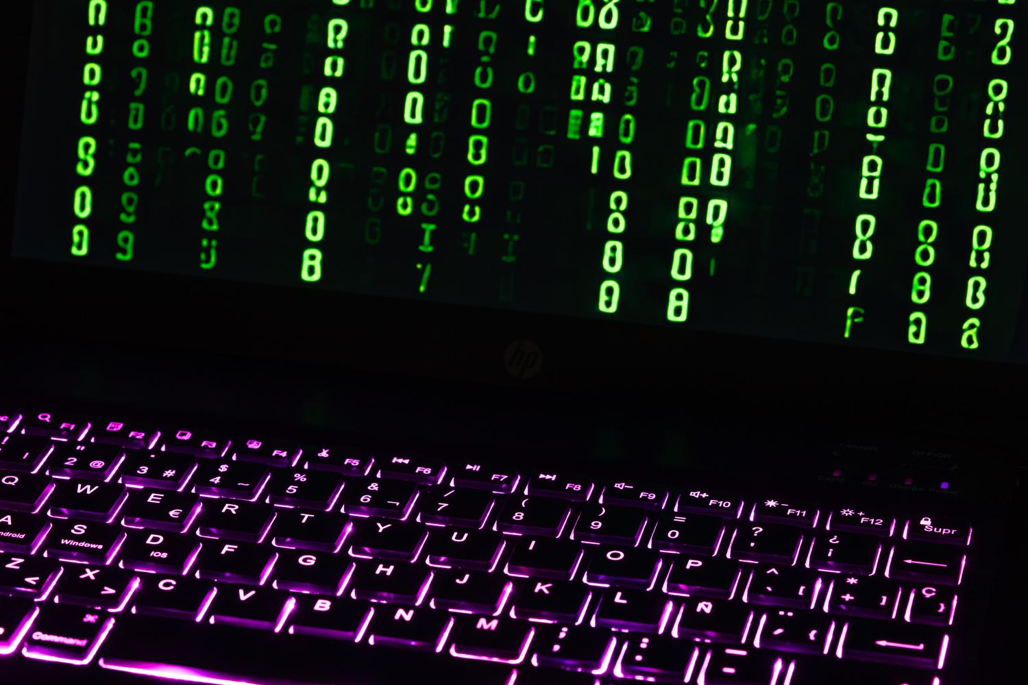 Teclado de portátil con proyecciones de código digital, evocando el funcionamiento técnico y el aislamiento de las sesiones temporales de IA.