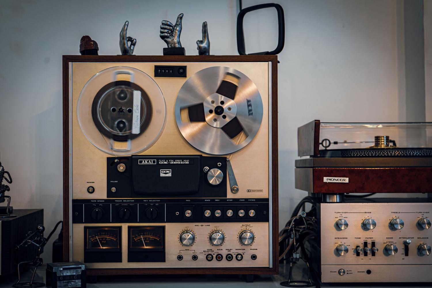 Equipo de audio vintage con un reproductor de cinta de bobina abierta, representando la tecnología de grabación de los Advision Studios en 1971.