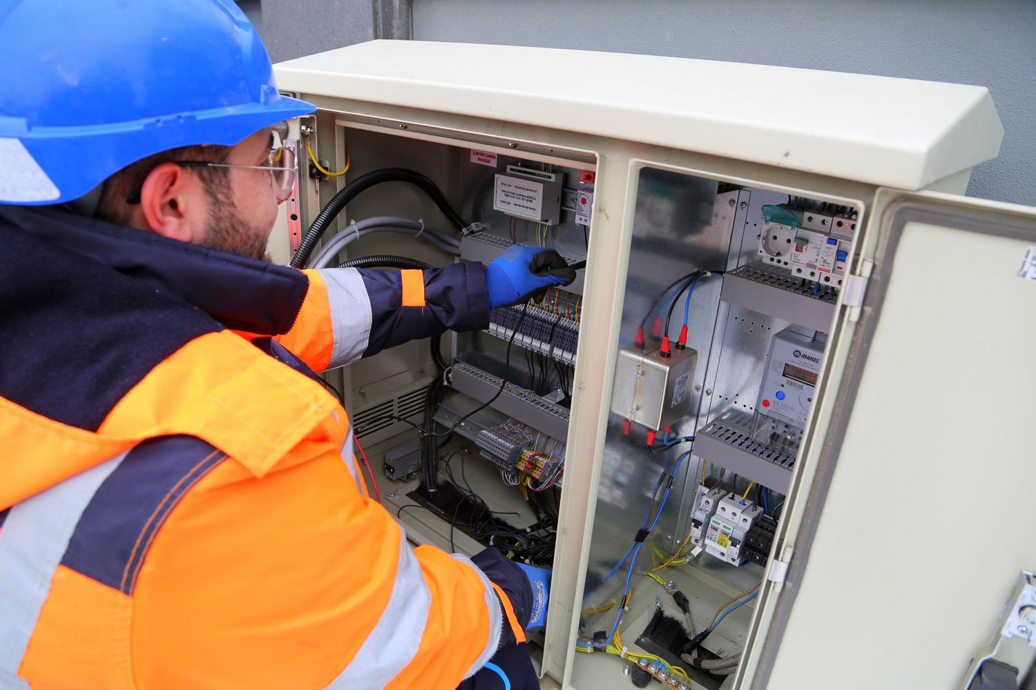 Electricista profesional trabajando en el mantenimiento de un panel eléctrico industrial