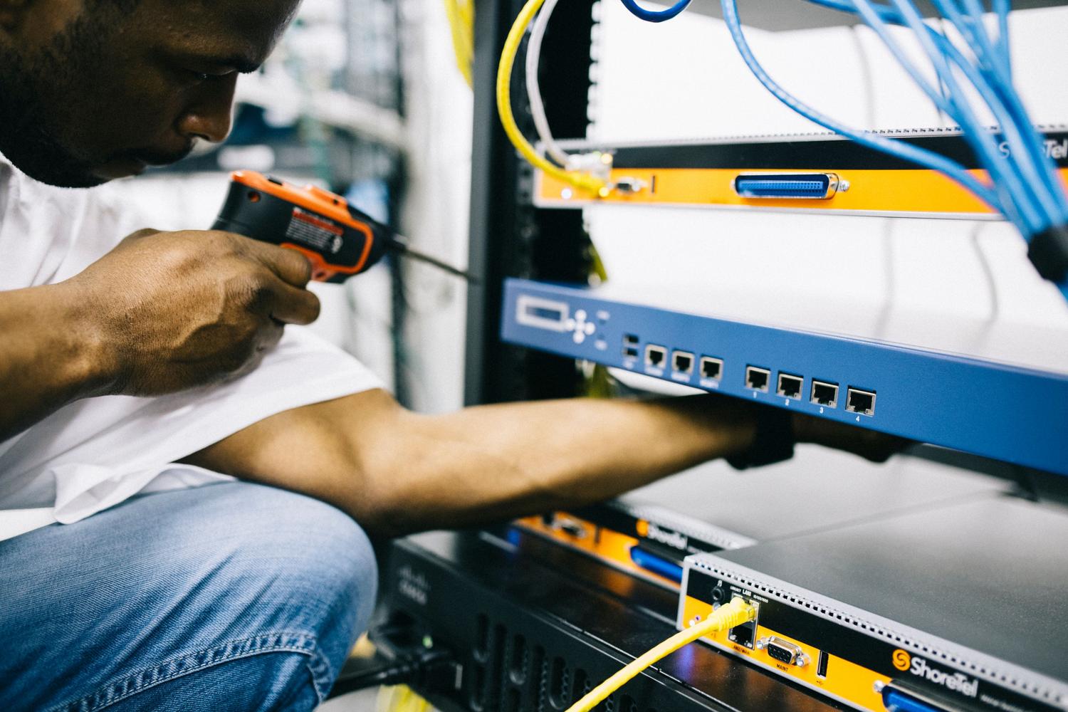 Técnico de IT realizando la instalación de hardware en un rack de servidores