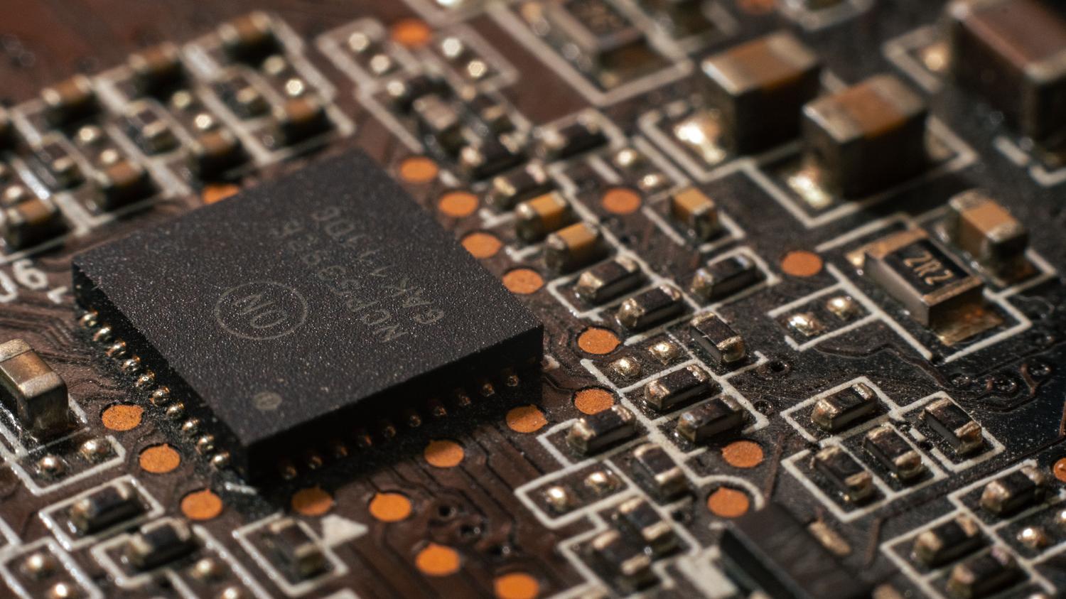 Detalle de una placa de circuito impreso con componentes electrónicos, ilustrando la infraestructura de hardware de IA.