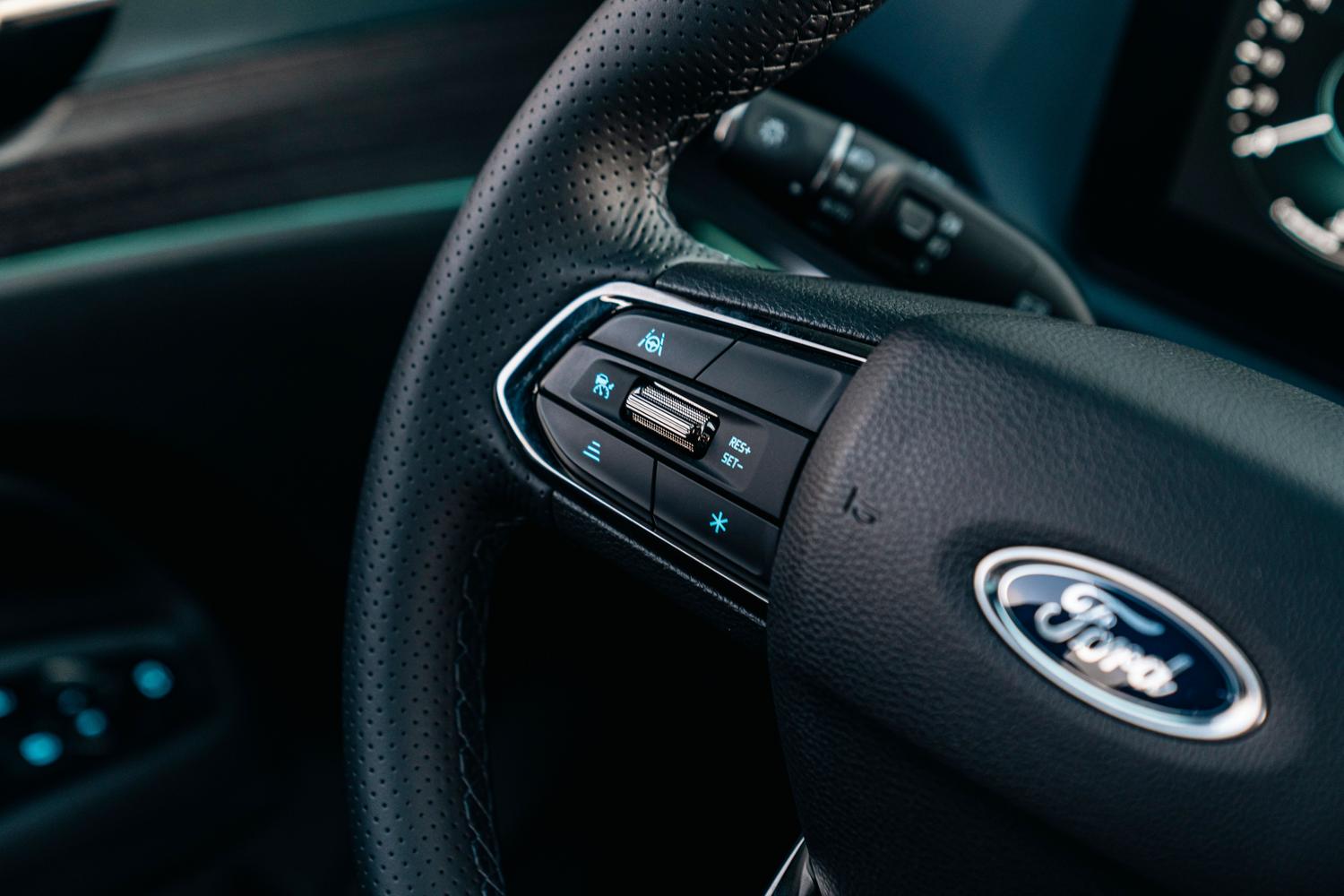 Detalle de los botones de control de crucero y asistencia al conductor en el volante de un coche moderno.