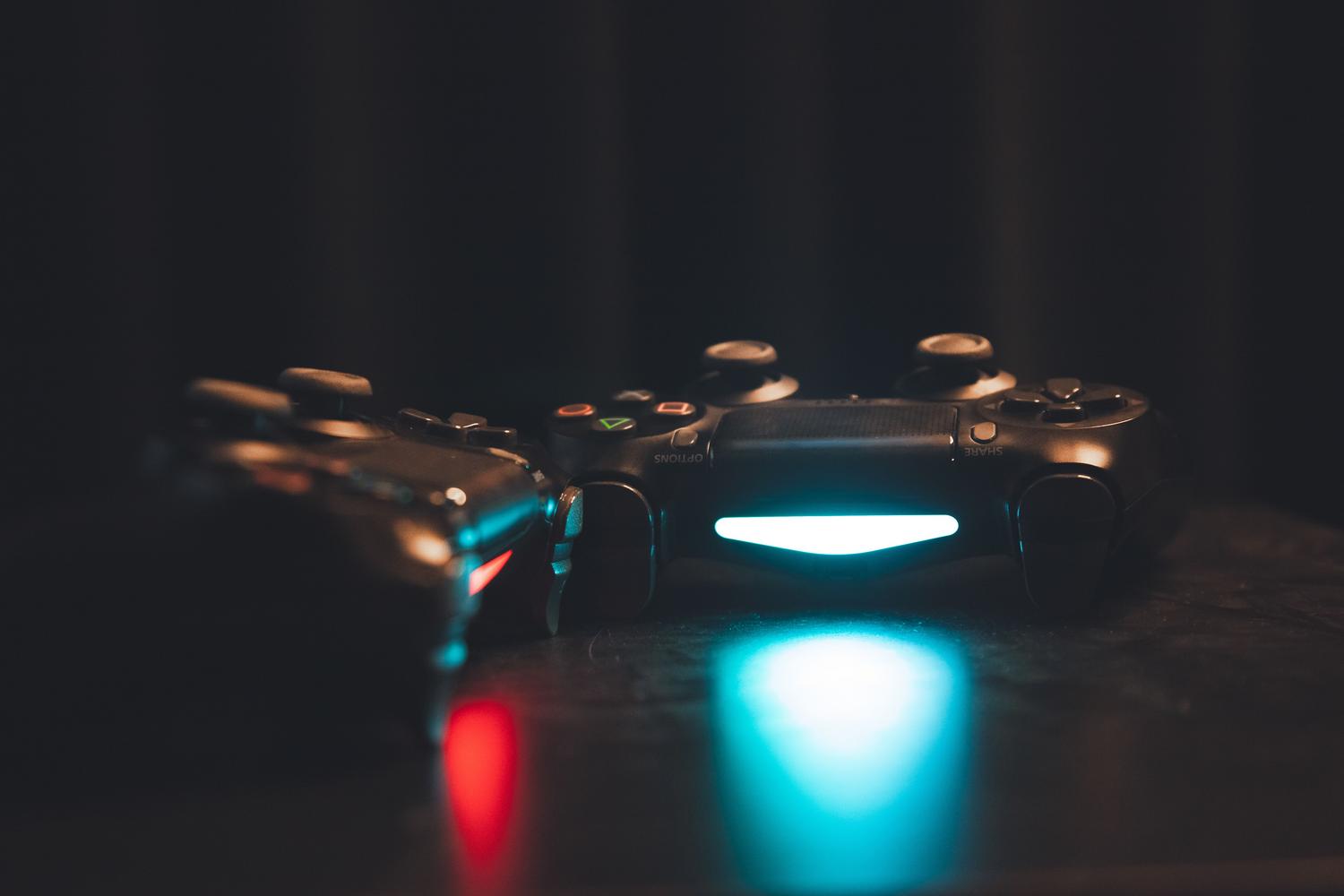 Mandos de videojuegos modernos con iluminación LED en un entorno oscuro y tecnológico.