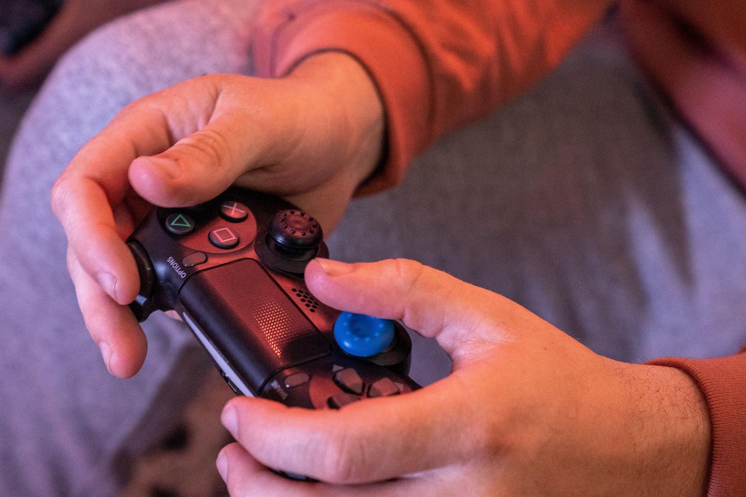 Primer plano de manos sujetando un mando de videojuegos, representando la memoria muscular y la automatización de los controles.