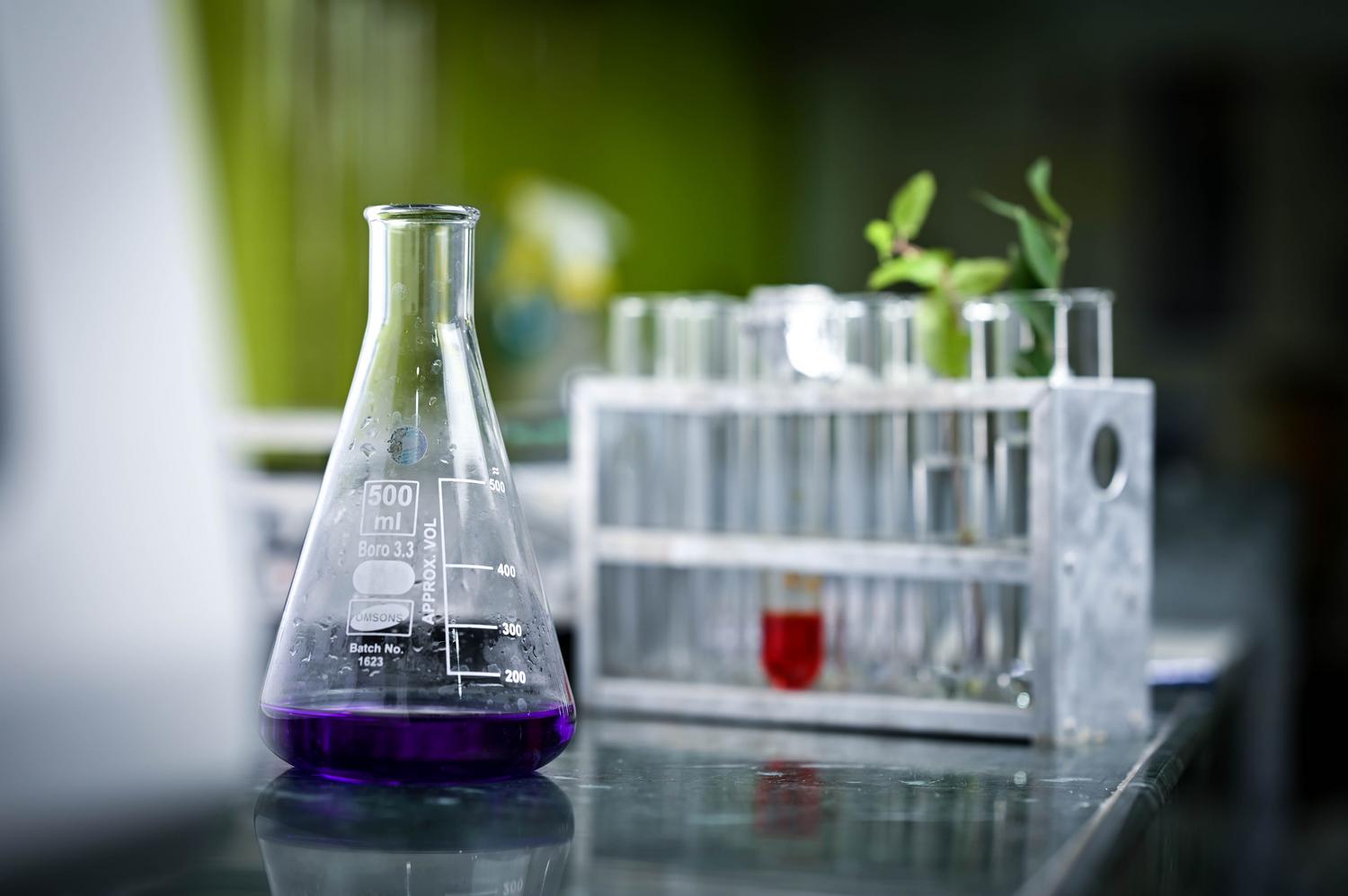 Matraz de laboratorio con líquido púrpura representando el análisis de la composición de líquidos complejos
