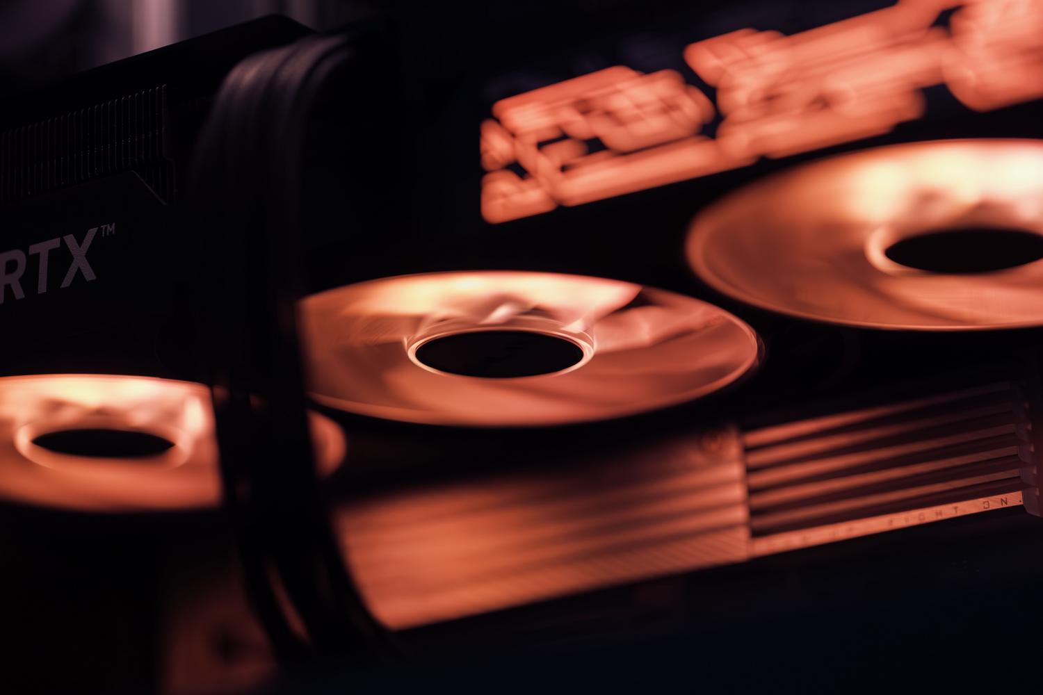 Primer plano de los ventiladores de una tarjeta gráfica gaming iluminados en rojo