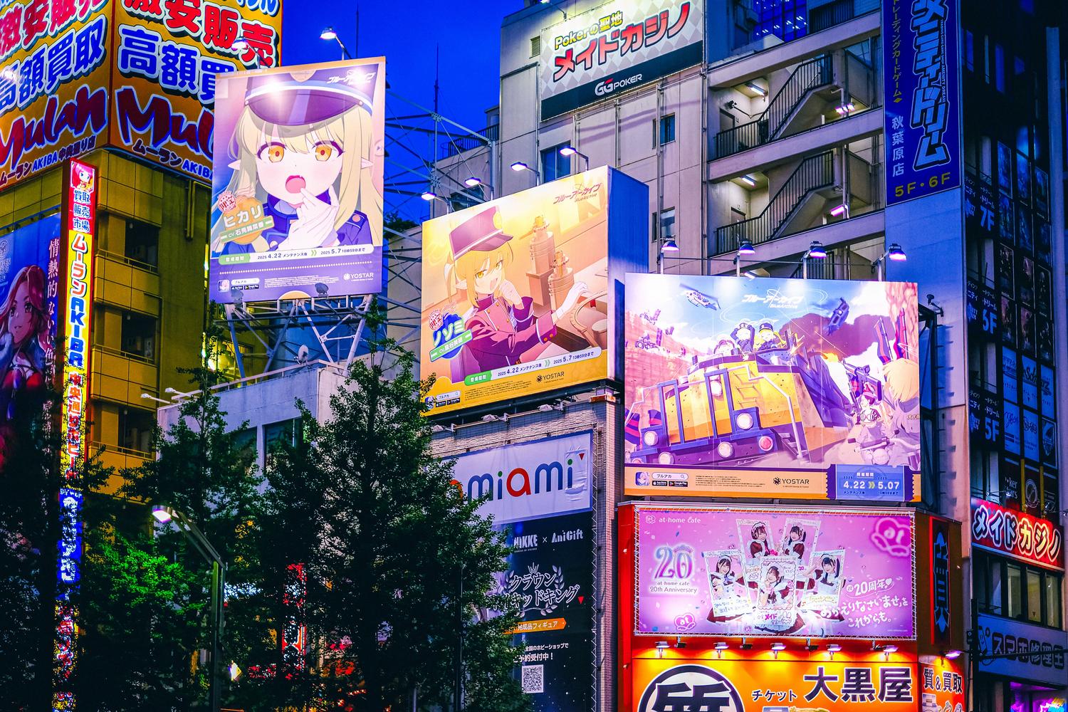 Vista nocturna de Akihabara en Tokio, el distrito electrónico, iluminada por vibrantes carteles y pantallas LED de anime.