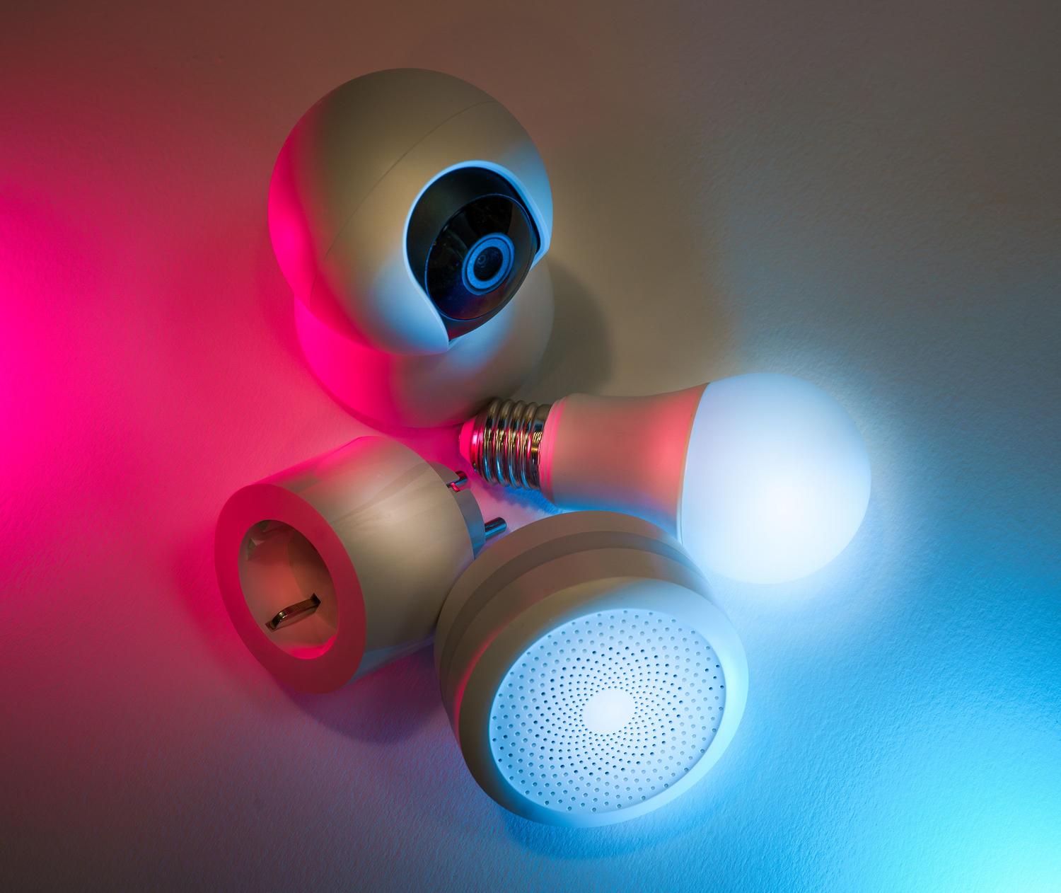 Un insieme di dispositivi smart home connessi, come telecamere e lampadine, con illuminazione tecnologica al neon, che rappresentano la gestione di più dispositivi. Un insieme di dispositivi smart home connessi, come telecamere e lampadine, con illuminazione tecnologica al neon, che rappresentano la gestione di più dispositivi.