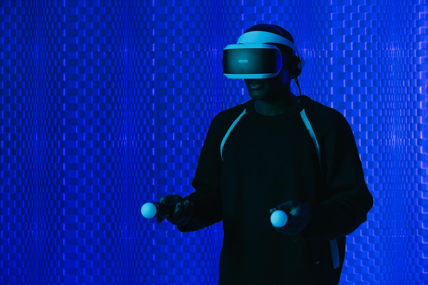 Una persona utilizza un visore per la realtà virtuale in un ambiente digitale futuristico, a dimostrazione della bassa latenza e dell'elevata velocità offerte dal Wi-Fi 7. Una persona utilizza un visore per la realtà virtuale in un ambiente digitale futuristico, a dimostrazione della bassa latenza e dell'elevata velocità offerte dal Wi-Fi 7.