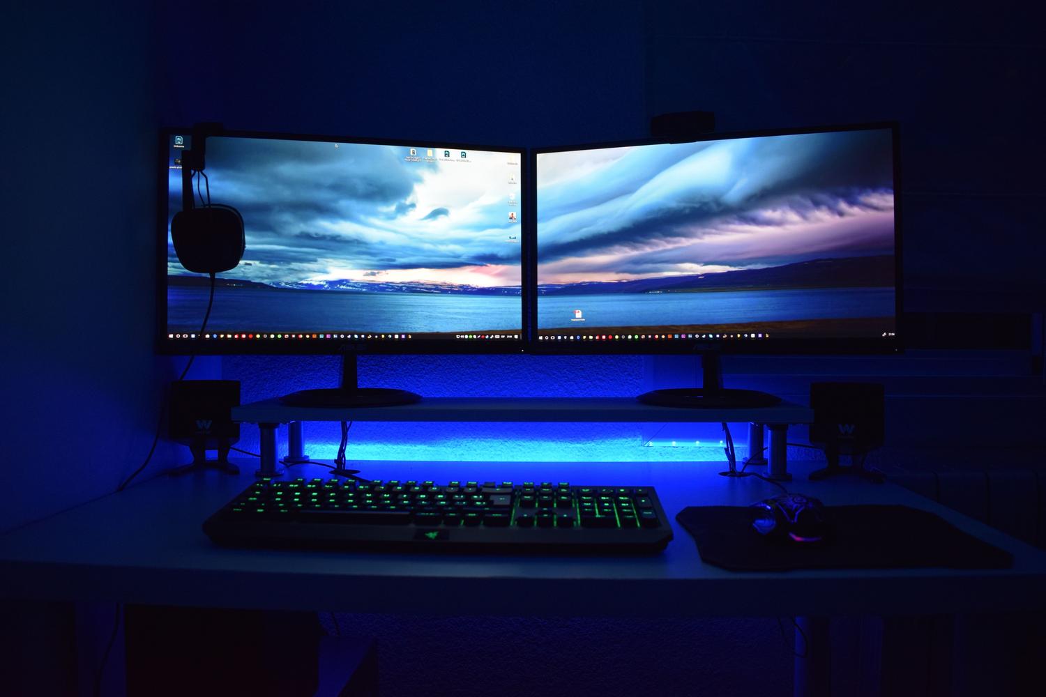 Escritorio gaming con doble monitor elevado sobre un soporte para mejorar la postura cervical y la visibilidad durante el uso intensivo.