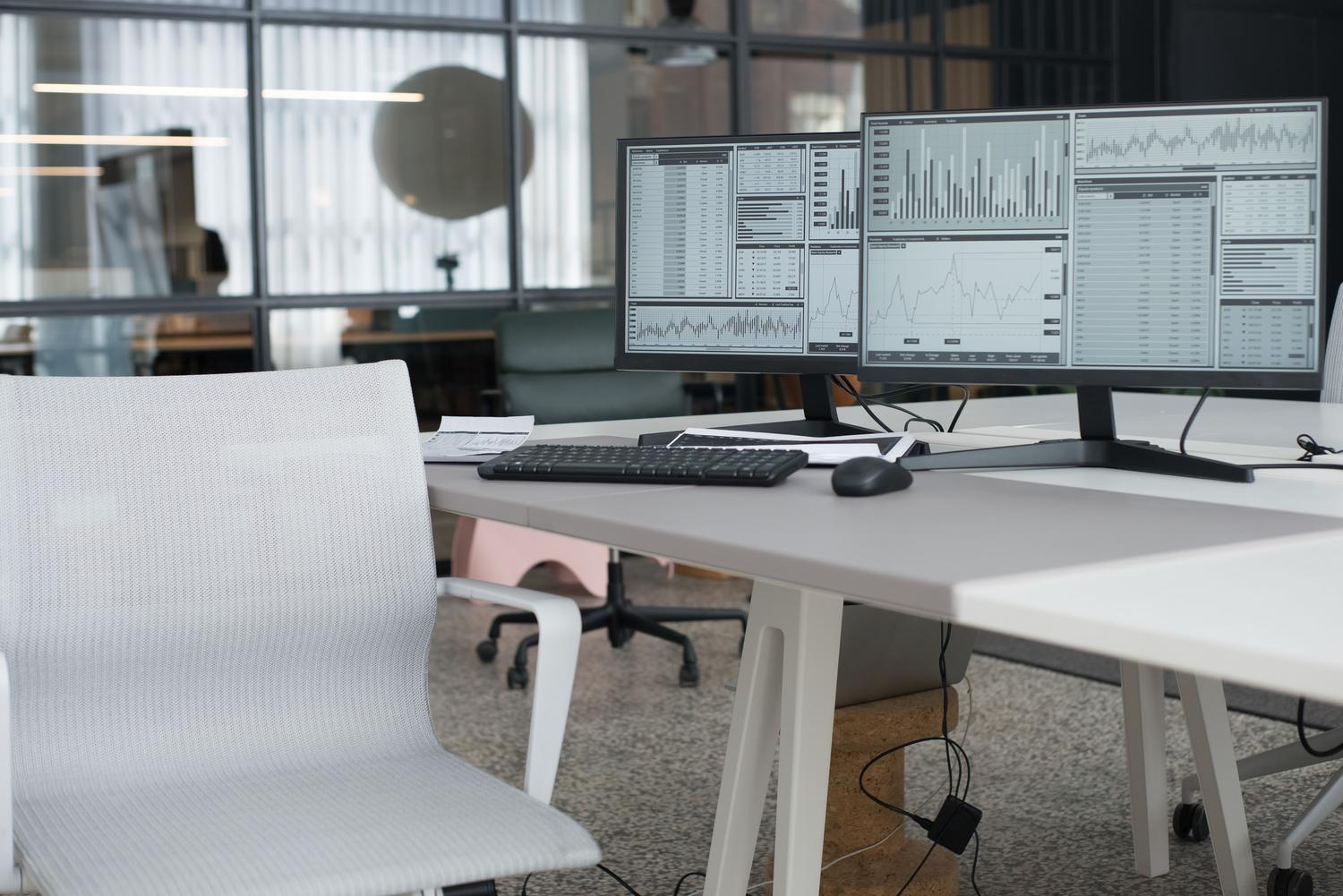 Espacio de trabajo profesional con configuración de doble pantalla y silla ergonómica, ideal para maximizar la productividad en entornos corporativos.