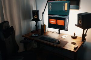 Setup de oficina moderno con dos monitores apilados verticalmente sobre brazos articulados, optimizando el espacio y la ergonomía visual.