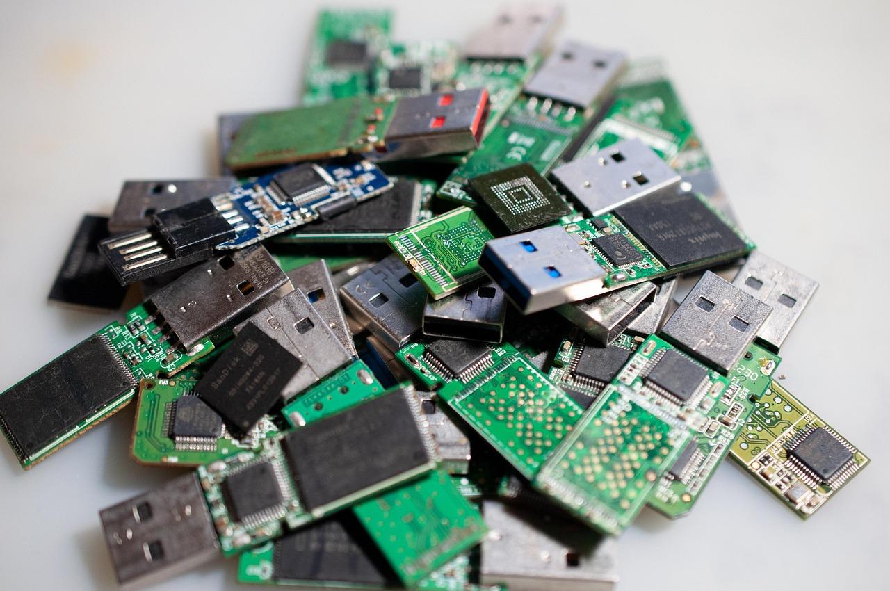 Conjunto de placas de circuitos impresos de memorias USB desmontadas, ilustrando el hardware interno y la optimización del sistema.