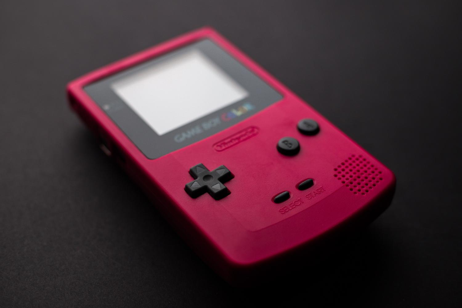 Detalle de una Game Boy Color roja, consola emblemática de la segunda generación de Pokémon.