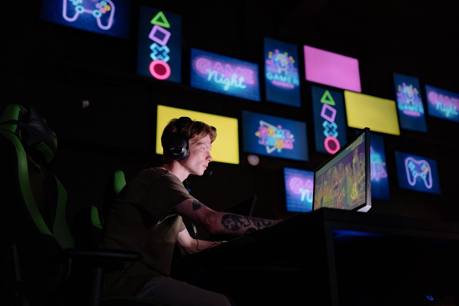 Focused gamer playing in a neon-lit room, representing the immersive experience of Smooth Motion.