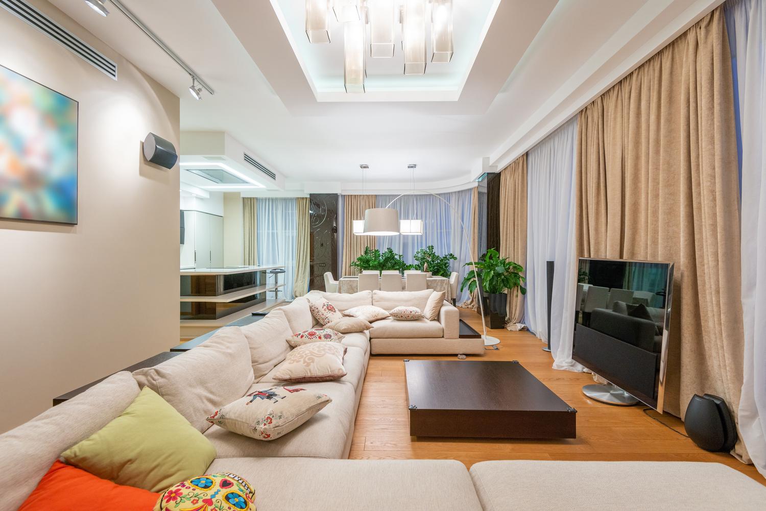 Salón moderno y luminoso con un televisor de gran tamaño integrado en la decoración minimalista.