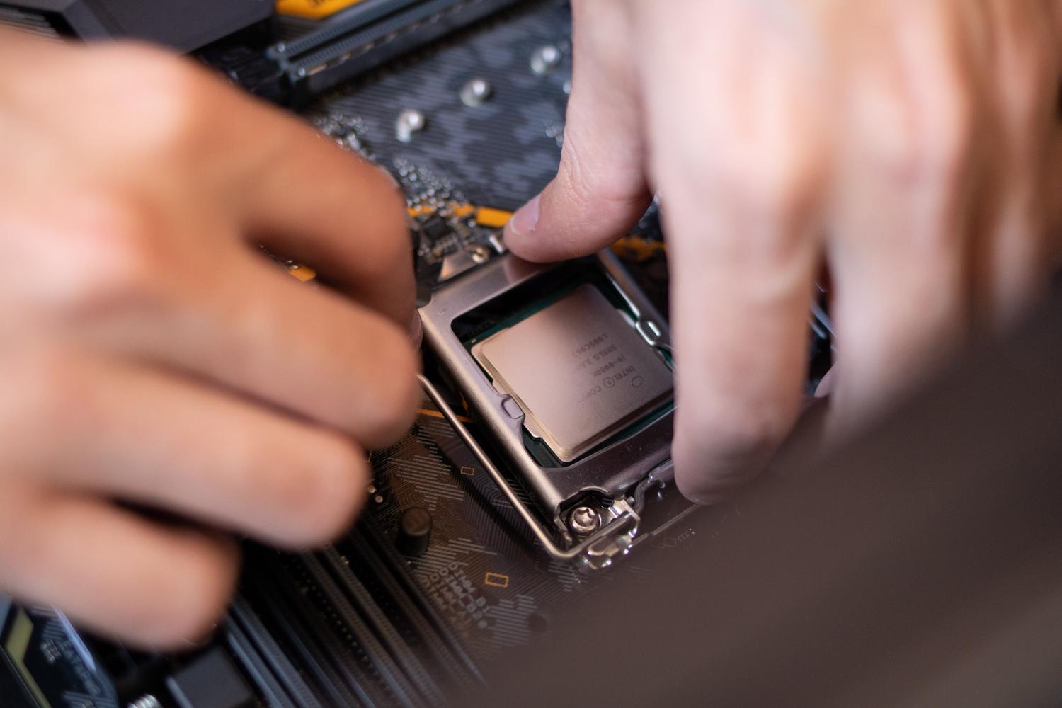 Manos instalando un procesador en una placa base, ilustrando la actualización de hardware.