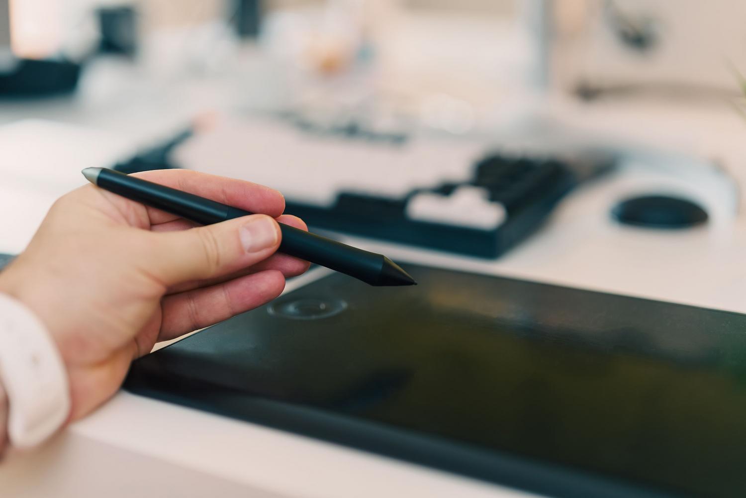 Primer plano de una mano utilizando un lápiz digital sobre una tableta, ideal para ilustrar el dibujo cuadro a cuadro.