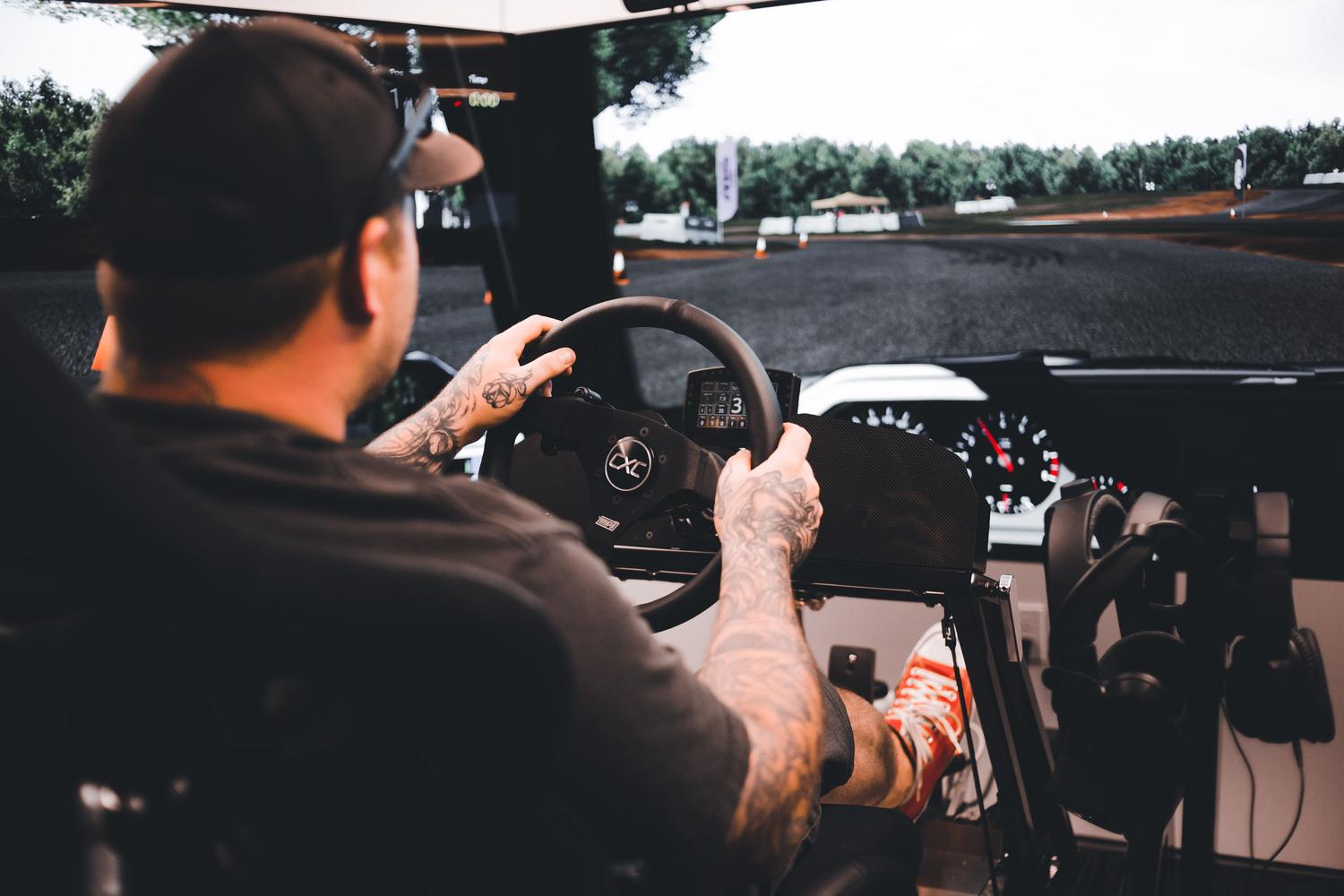 Persona utilizando un simulador de conducción detallado con volante y monitor para ajustar el FOV