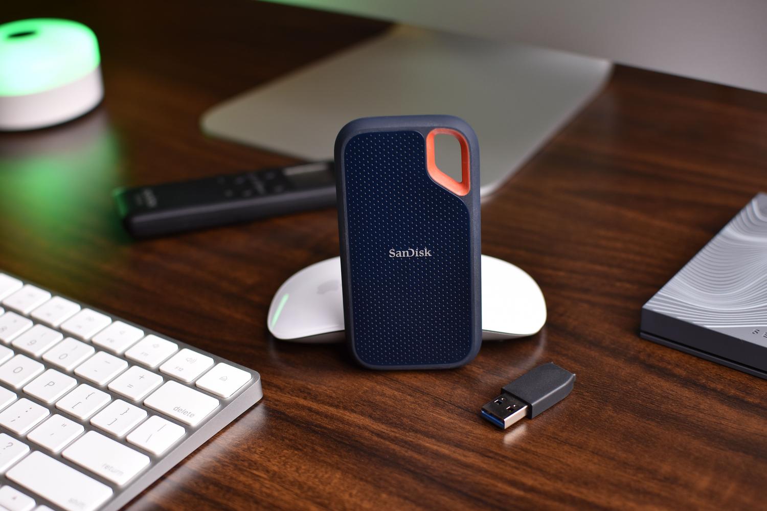 Configuración de escritorio con un SSD SanDisk y teclado, destacando la tecnología de almacenamiento portátil