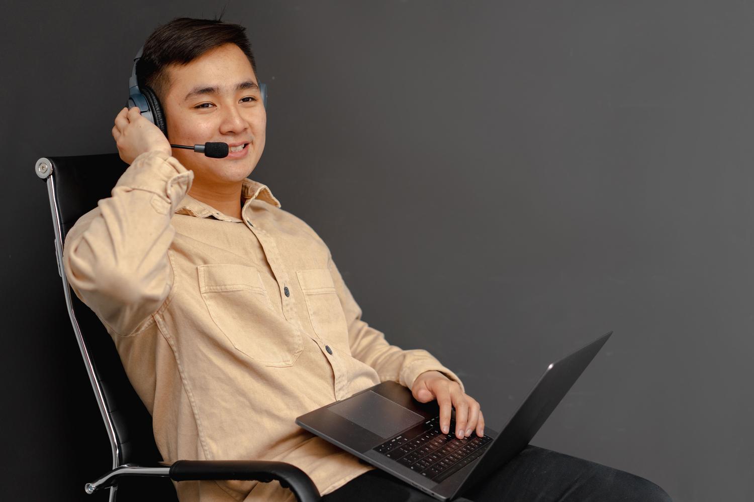 Agente de servicio al cliente sonriente utilizando un portátil y auriculares