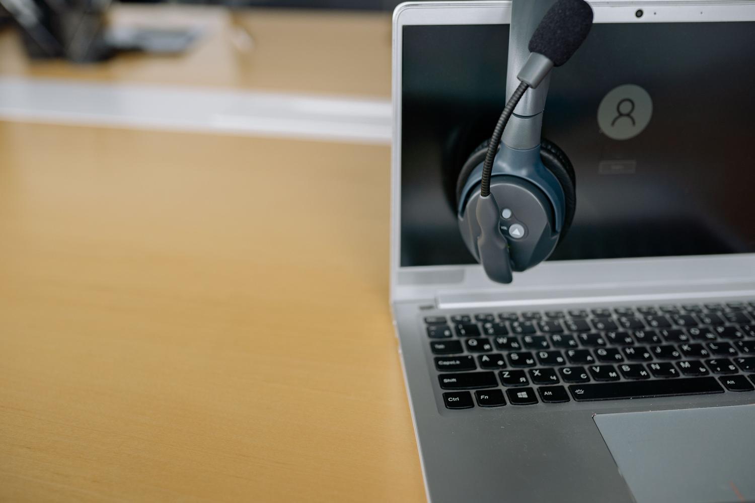 Primer plano de unos auriculares sobre un ordenador portátil simbolizando la comunicación con soporte técnico