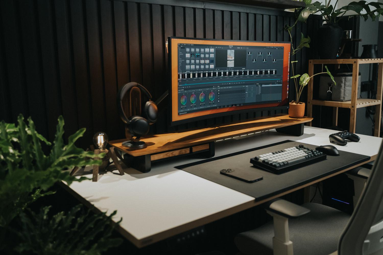 Escritorio de oficina sofisticado con un monitor ultrawide curvo, perfecto para ilustrar los formatos de pantalla extendidos y la inmersión visual.