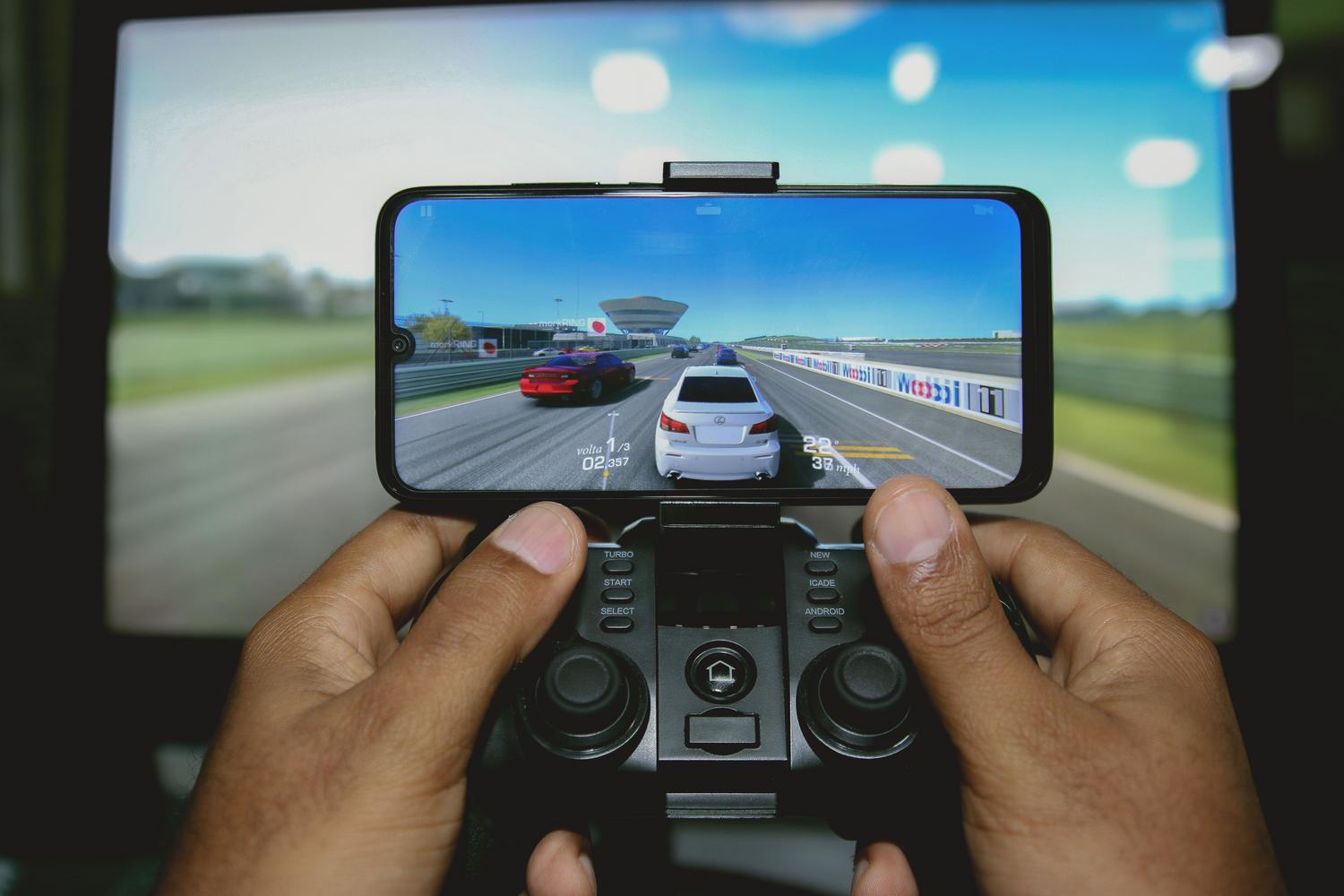 Orang yang menggunakan pengawal permainan yang disambungkan ke telefon pintar Android untuk menavigasi. Orang yang menggunakan pengawal permainan yang disambungkan ke telefon pintar Android untuk menavigasi.