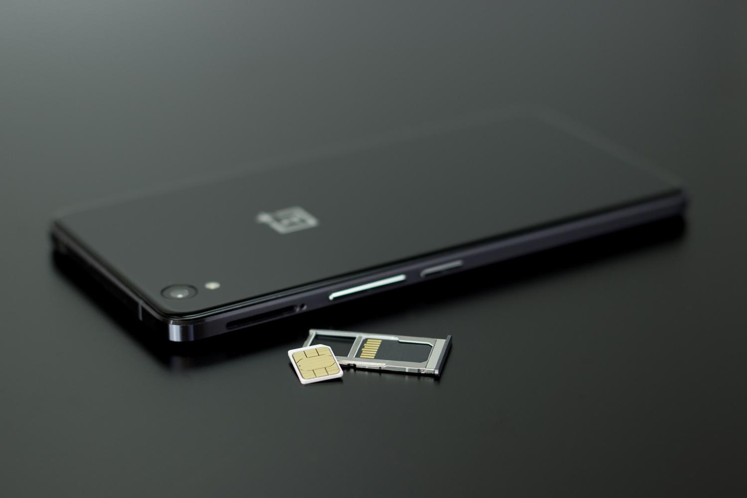 Primer plano de un smartphone con su tarjeta SIM y la bandeja de extracción