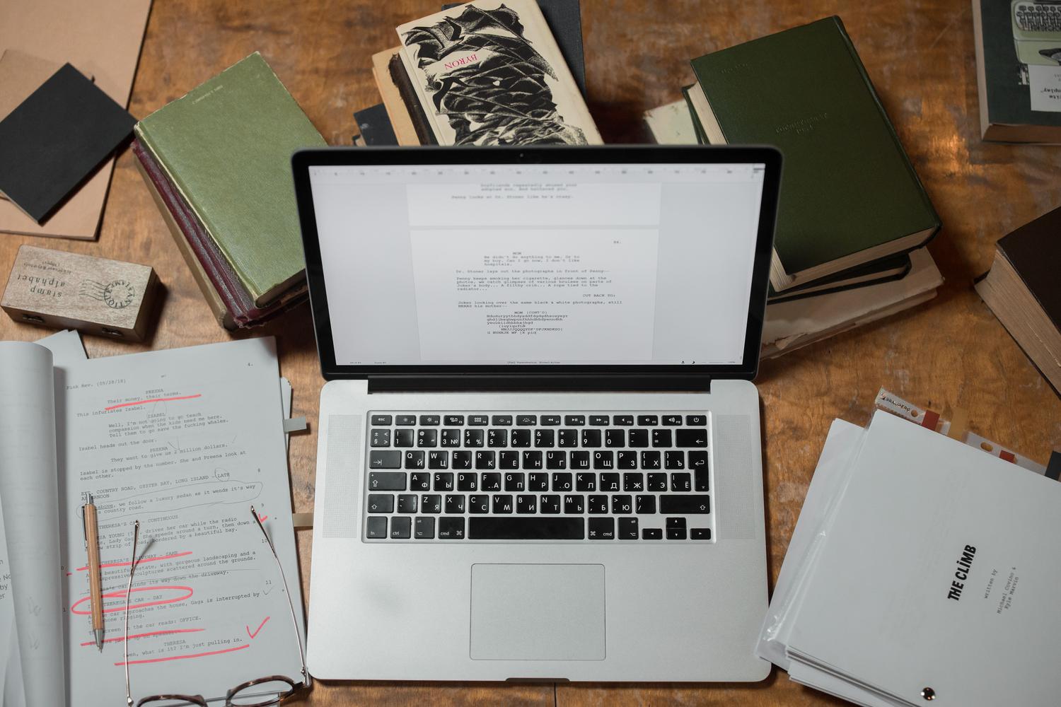 Portátil en un escritorio rodeado de documentación, sugiriendo un entorno de configuración técnica y trabajo de automatización.