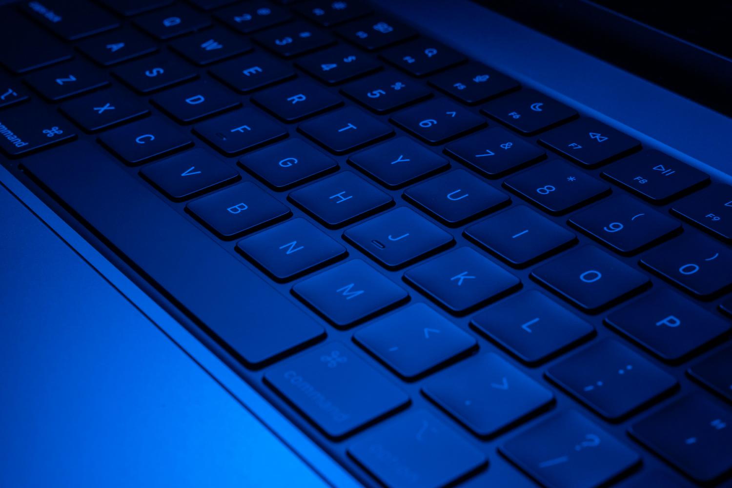 Detalle tecnológico de un teclado de portátil iluminado, sugiriendo el uso de herramientas avanzadas de software.