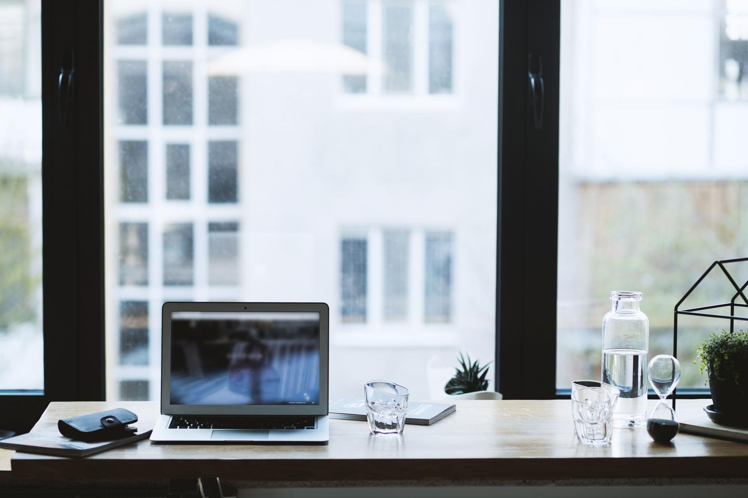 Espacio de trabajo moderno y organizado con un portátil, reflejando la optimización del entorno digital.