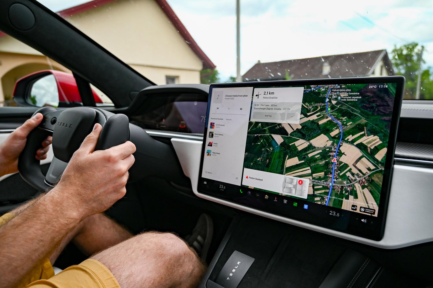 Conductor utilizando la pantalla central de un vehículo eléctrico para navegar, destacando la conectividad y seguridad vial.