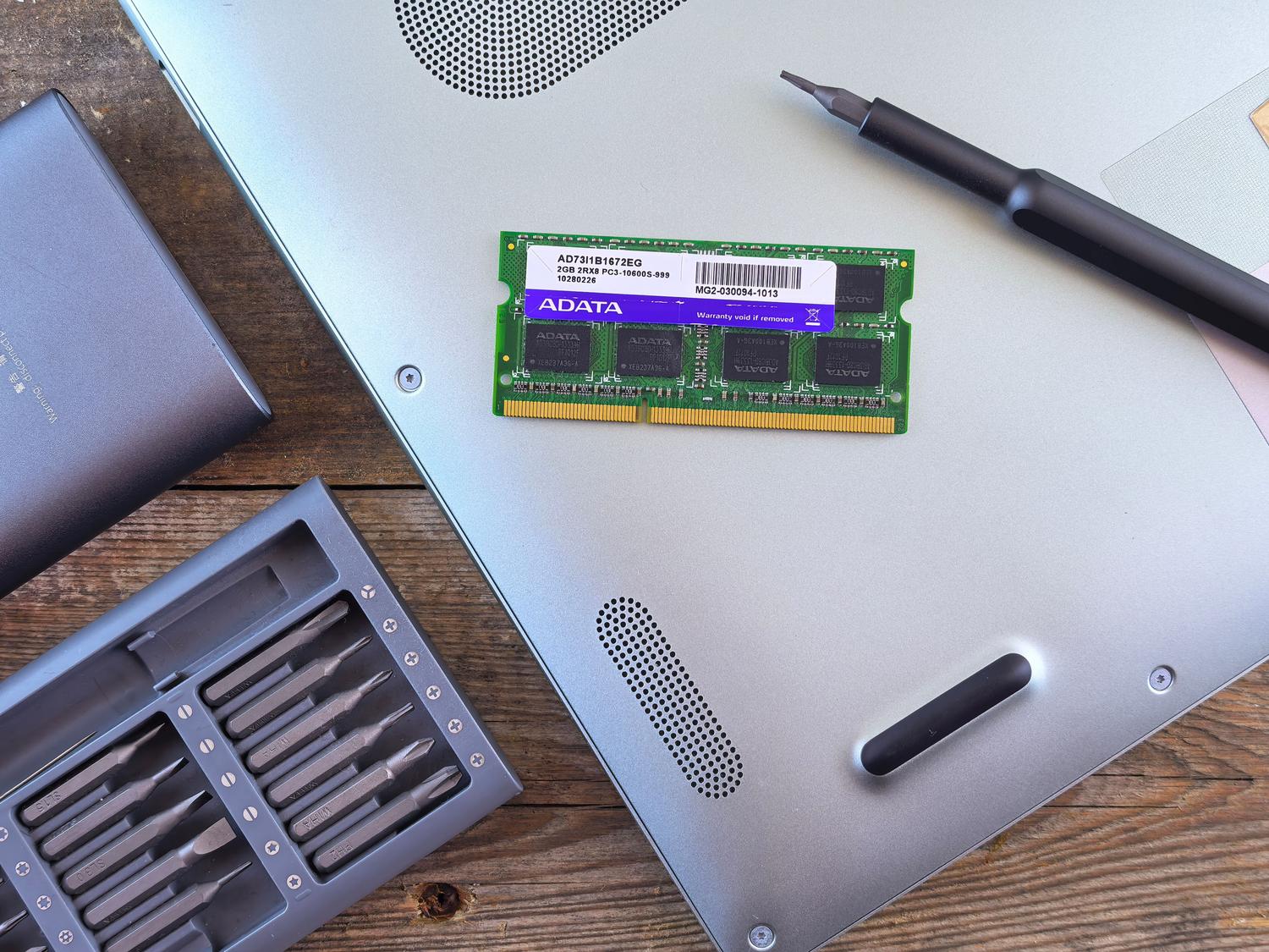 Módulo de memoria RAM SODIMM y herramientas de precisión para la ampliación de memoria en un portátil.
