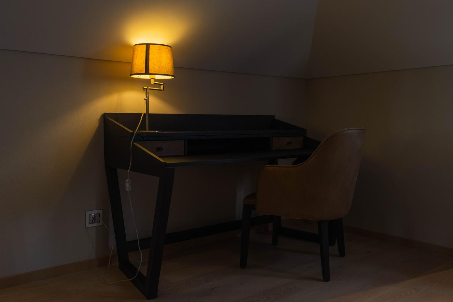 Rincón de trabajo acogedor en espacio reducido con iluminación cálida y silla confortable
