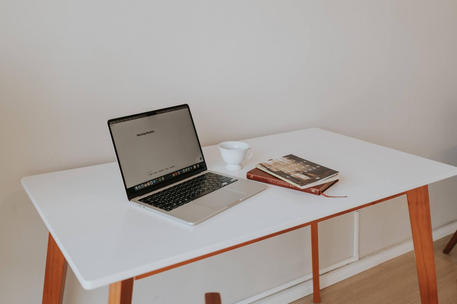 Escritorio de estilo escandinavo con tablero blanco y patas de madera, ideal para estudiar