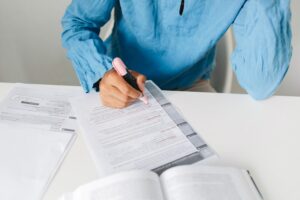 Persona resaltando palabras en un libro para identificar la acentuación y reglas gramaticales.