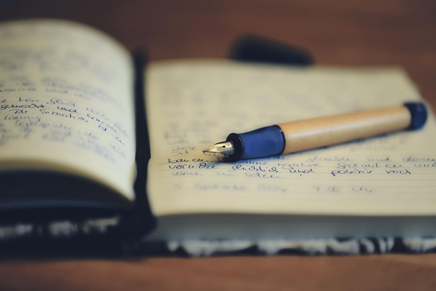 Una pluma estilográfica elegante sobre un cuaderno abierto, simbolizando el cuidado en la escritura y la acentuación.