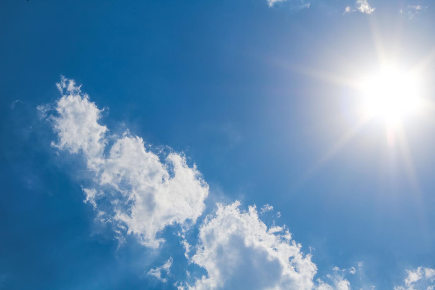 Sol brillante iluminando un cielo azul con nubes blancas, representando la palabra monosílaba sol.