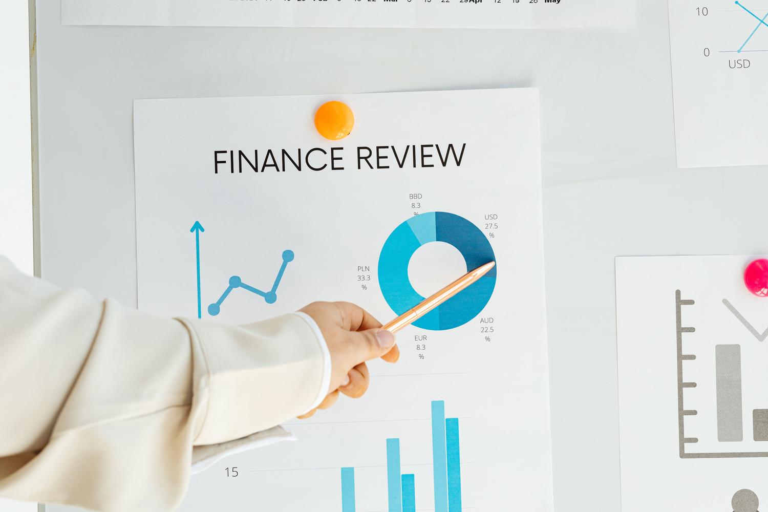 Primer plano de una mano analizando un informe financiero con gráficos, representando el cálculo del goodwill y la due diligence.