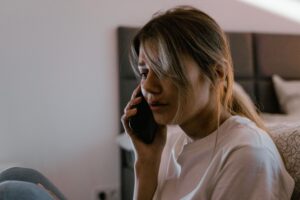 Mujer con expresión preocupada hablando por teléfono, representando la frustración de perder el historial de llamadas.