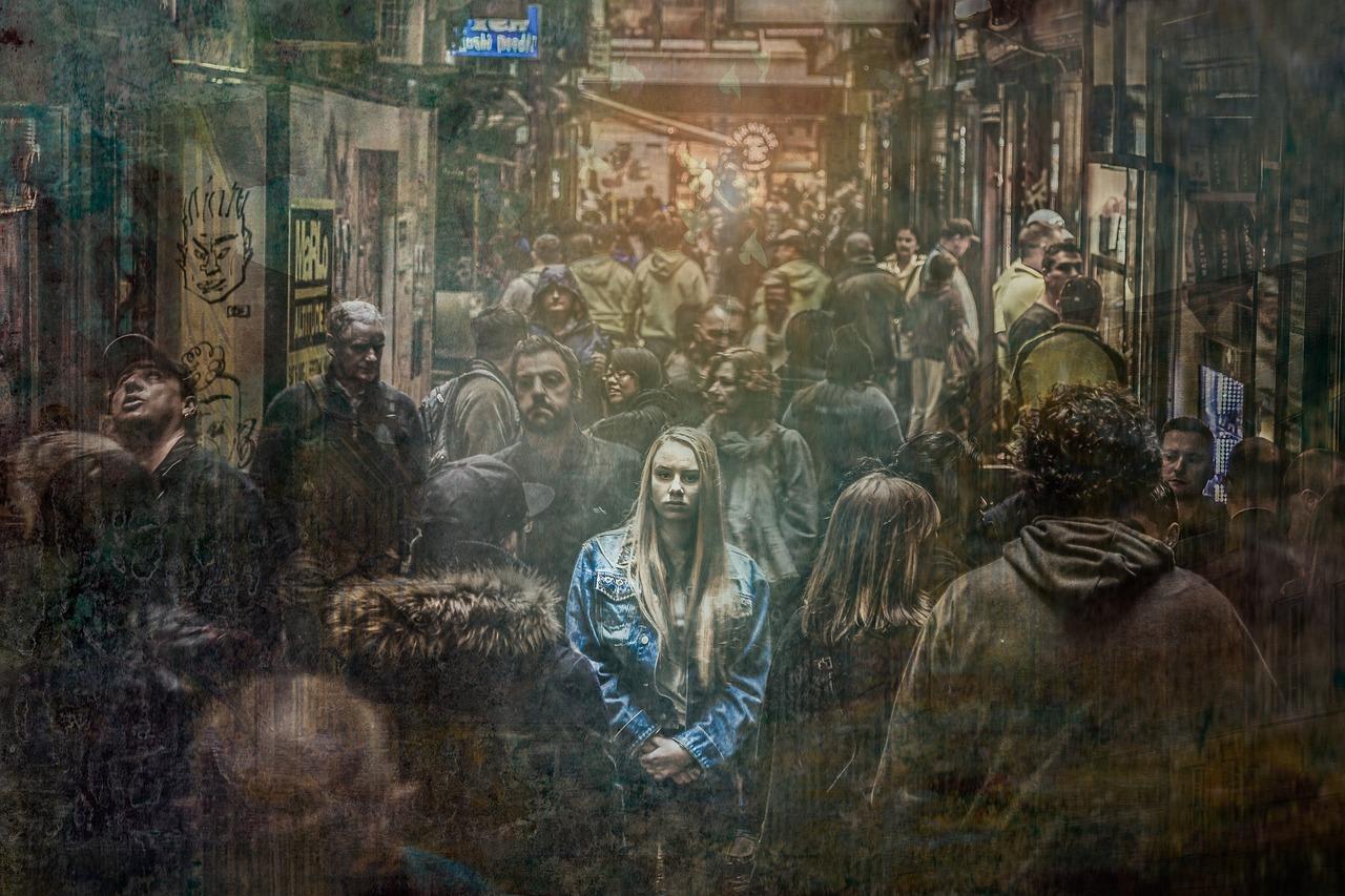 Mujer con expresión neutra en medio de una multitud urbana borrosa, ilustrando el aislamiento social y la desconexión.