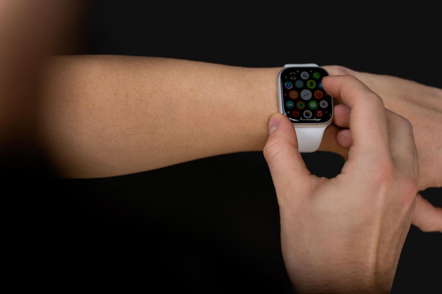 Primer plano de una persona interactuando con un smartwatch, ilustrando el ecosistema de dispositivos IoT y BlueOS.