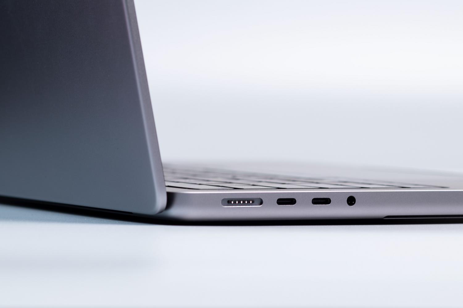 Vista detallada de los puertos laterales de un ordenador portátil moderno, sugiriendo la acción de probar diferentes puertos USB para solucionar errores de conexión.