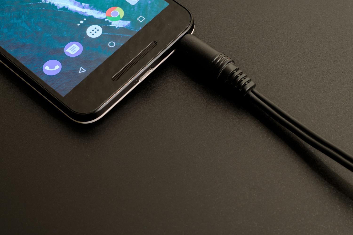 Primer plano de un smartphone Android moderno conectado, ilustrando el contexto de un dispositivo móvil en proceso de reparación o transferencia de datos.